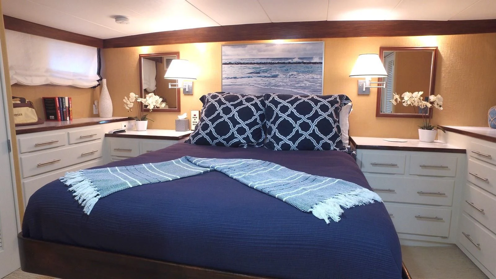 a bed with a blue comforter aboard BAREFOOT V Yacht for Sale