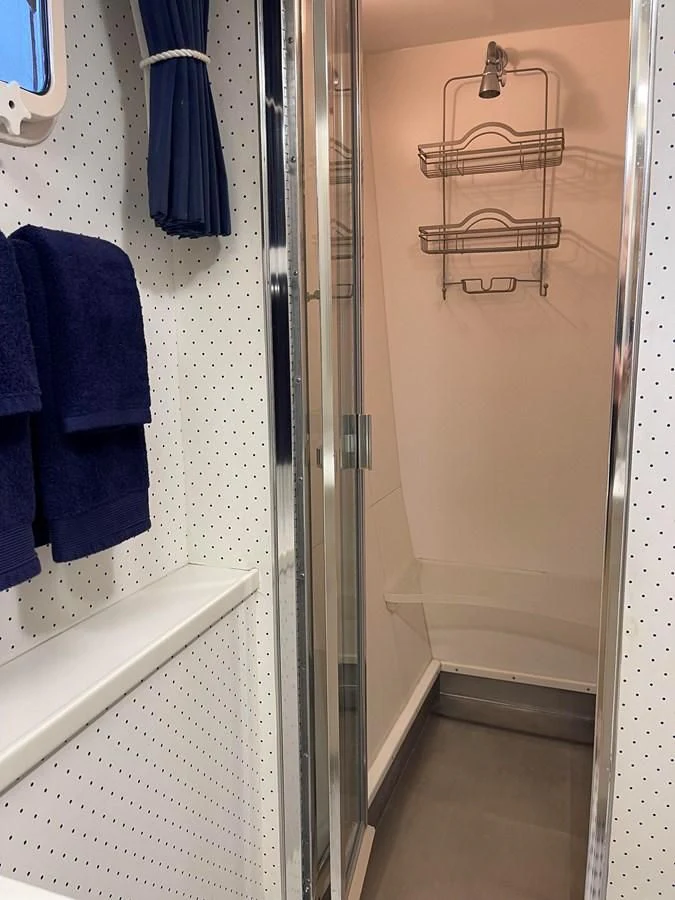 a shower with a towel on the wall aboard BAREFOOT V Yacht for Sale