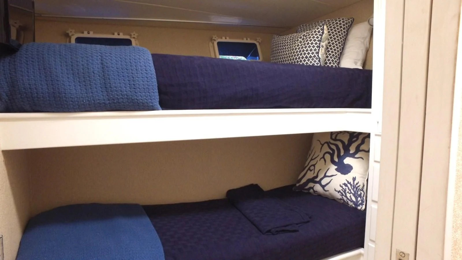 a bed with blue pillows aboard BAREFOOT V Yacht for Sale