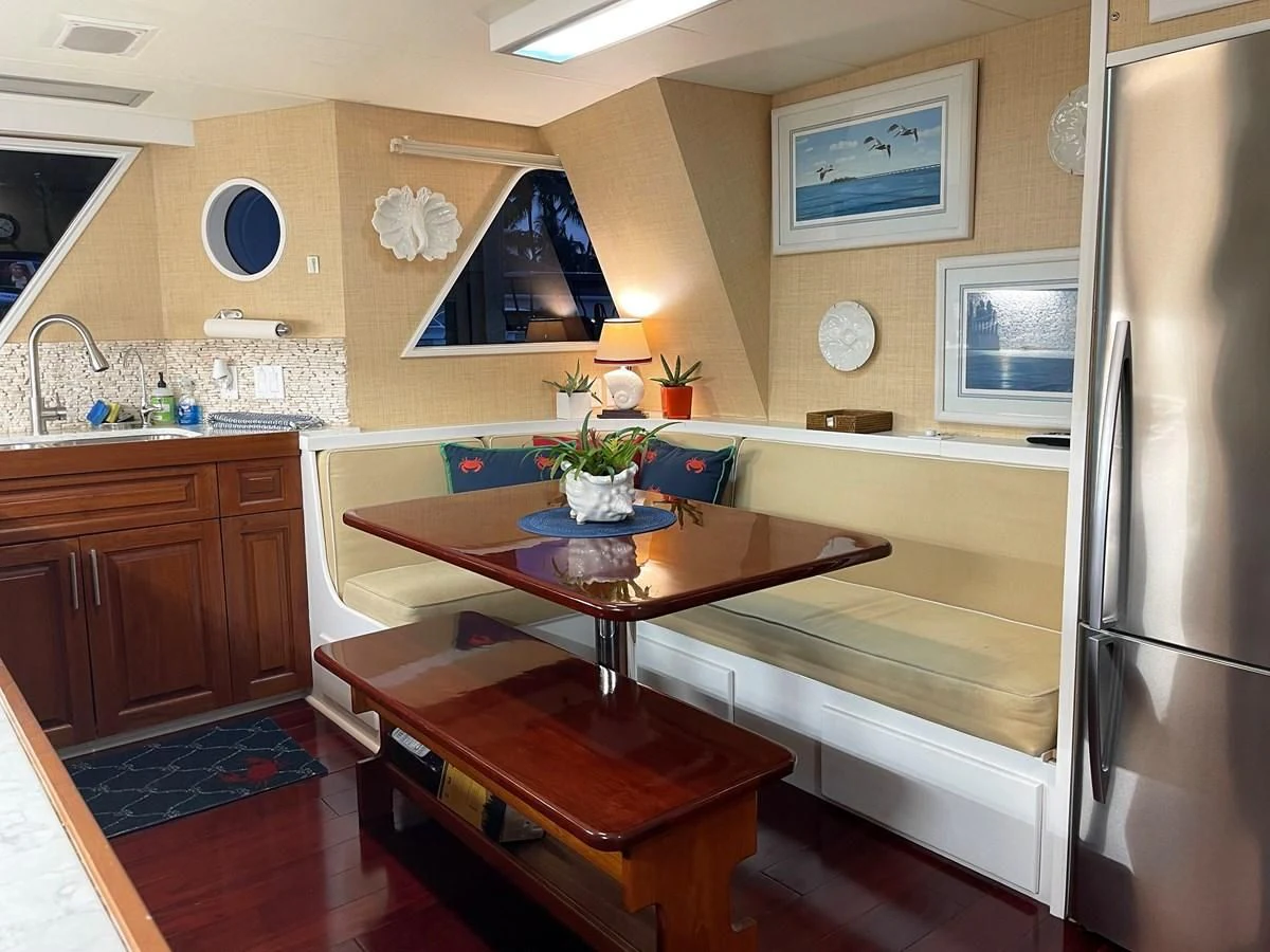 a kitchen with a table and a tv aboard BAREFOOT V Yacht for Sale