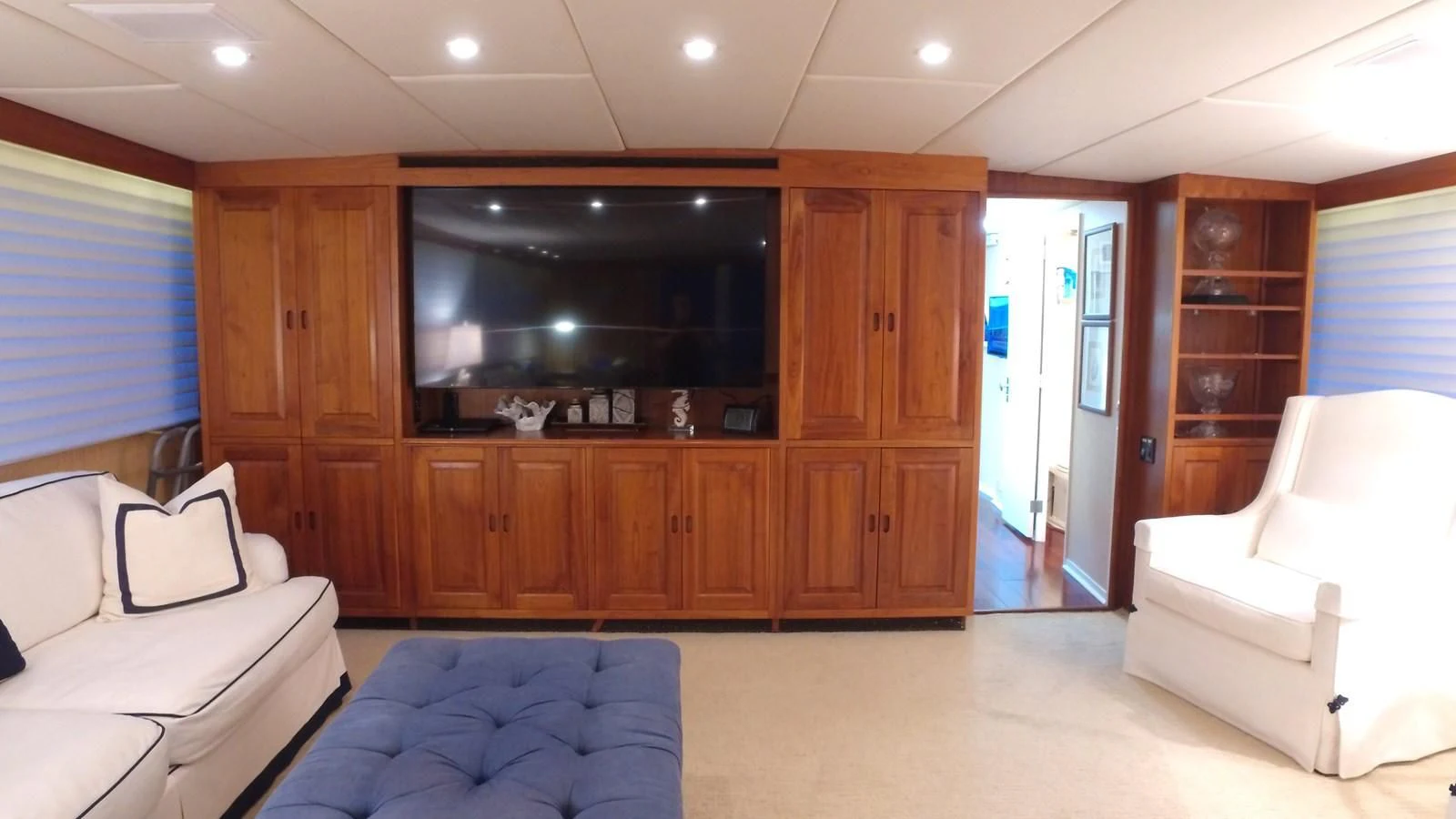 a living room with a large wood cabinet and a couch aboard BAREFOOT V Yacht for Sale