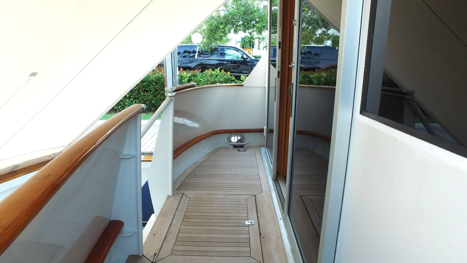 a wooden deck with a view of a street and cars aboard BAREFOOT V Yacht for Sale