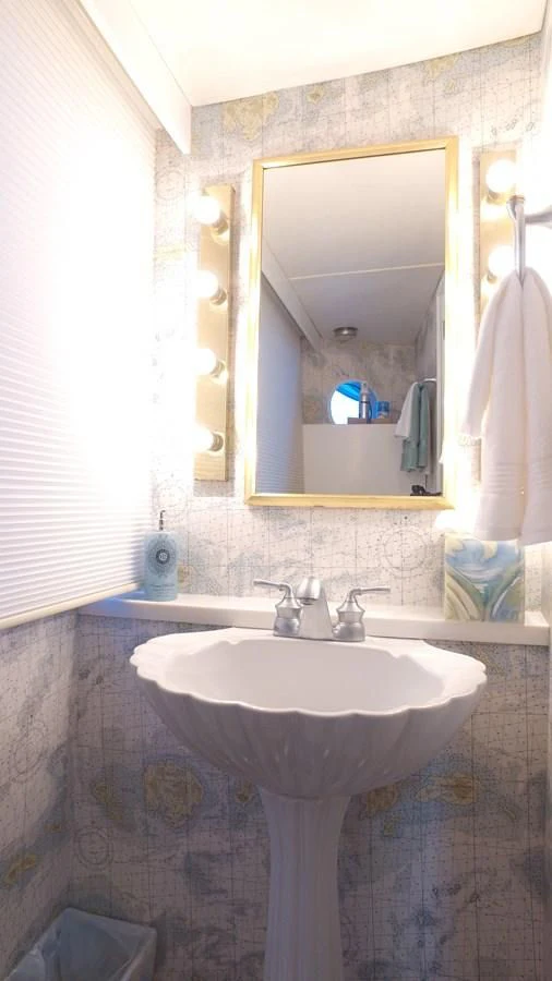 a bathroom with a round mirror aboard BAREFOOT V Yacht for Sale