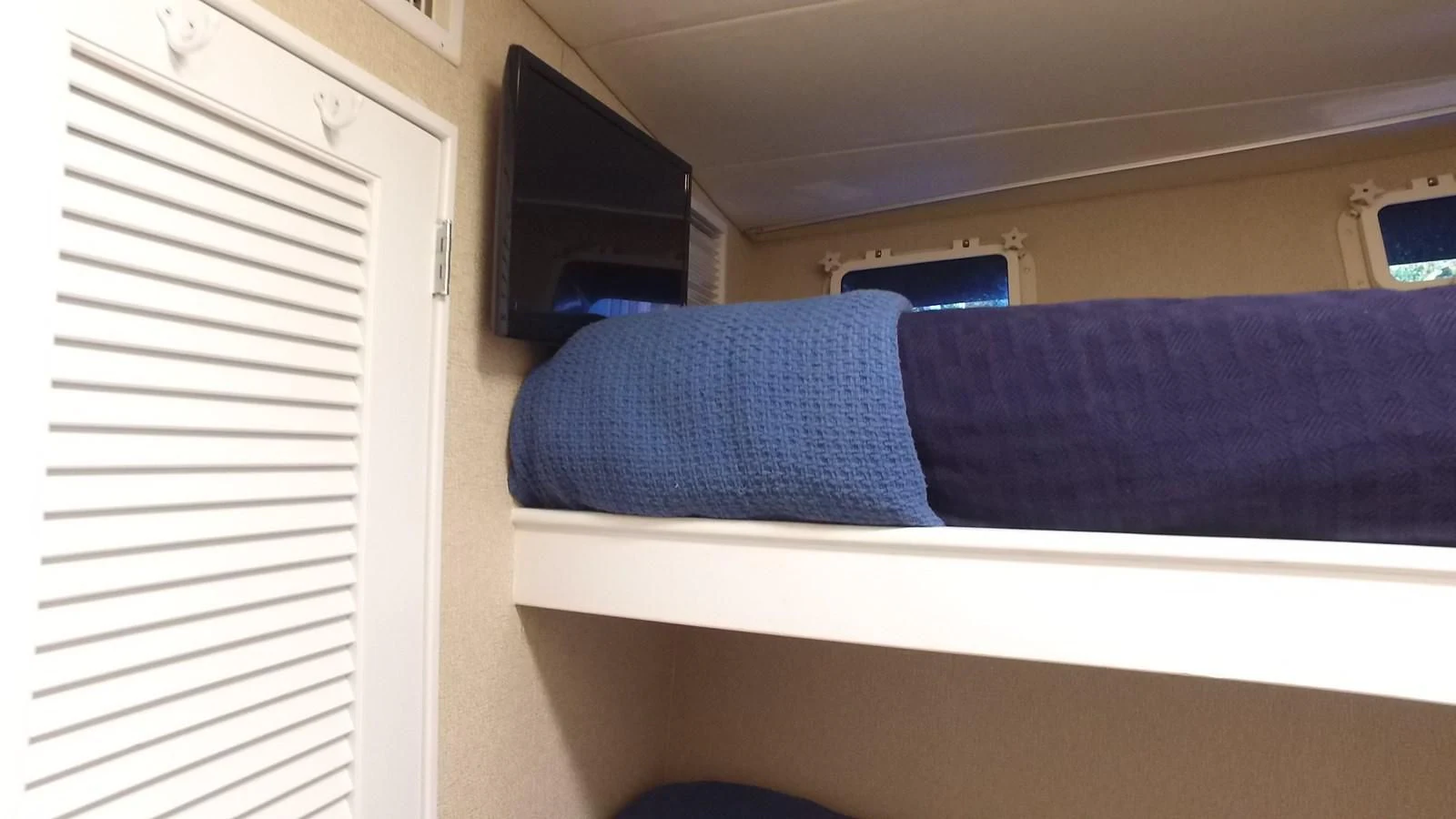 a bed with a blue sheet aboard BAREFOOT V Yacht for Sale