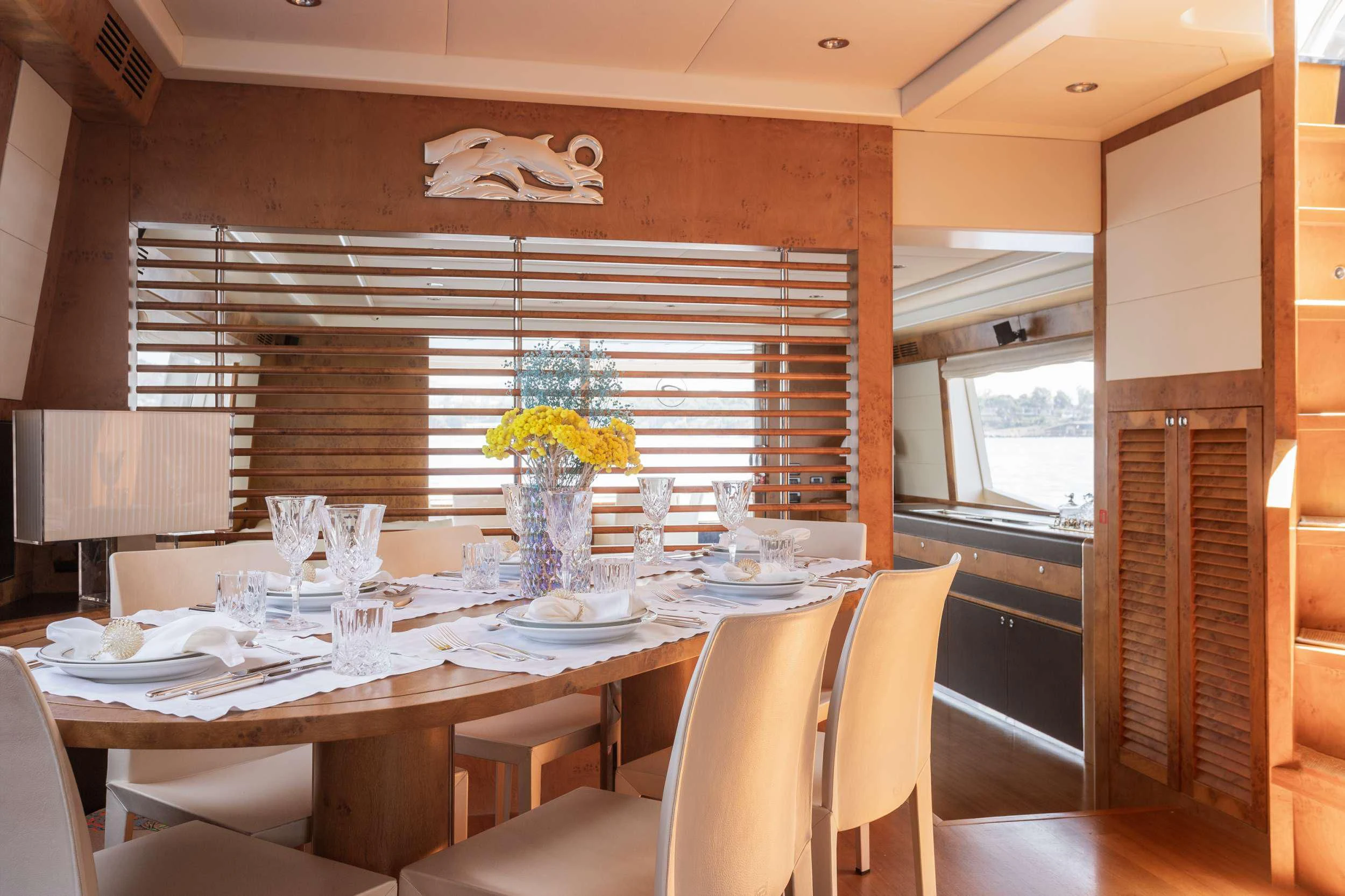 a dining table with a vase of flowers on it aboard ANLIA Yacht for Sale