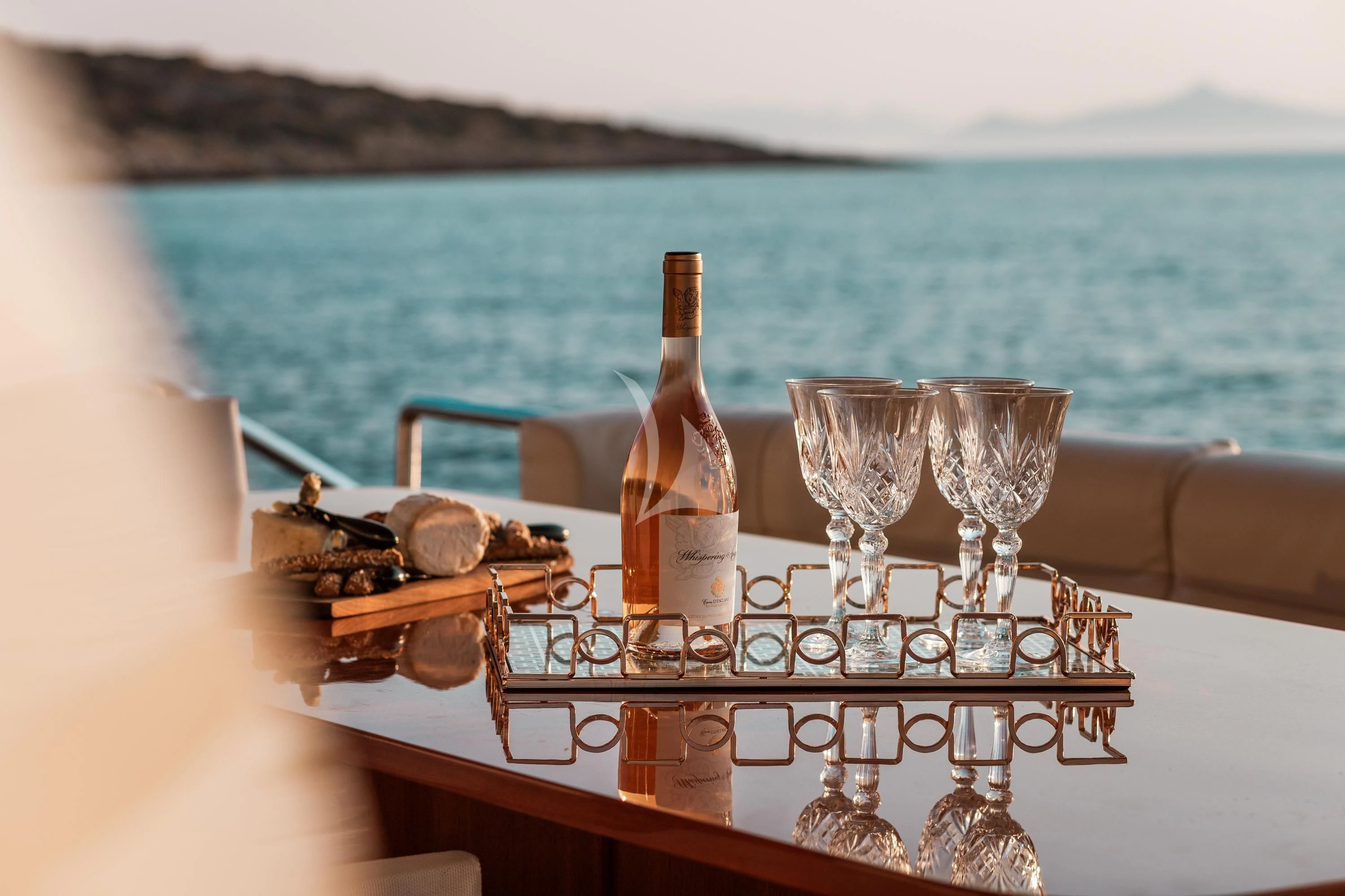 a bottle and glasses on a table aboard ANLIA Yacht for Sale