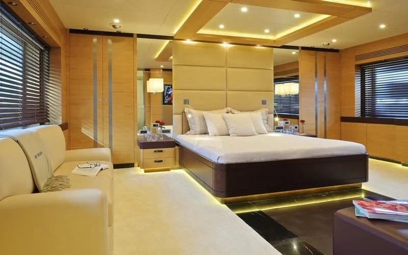 a large bedroom with a bed and a couch aboard TATIANA I Yacht for Sale