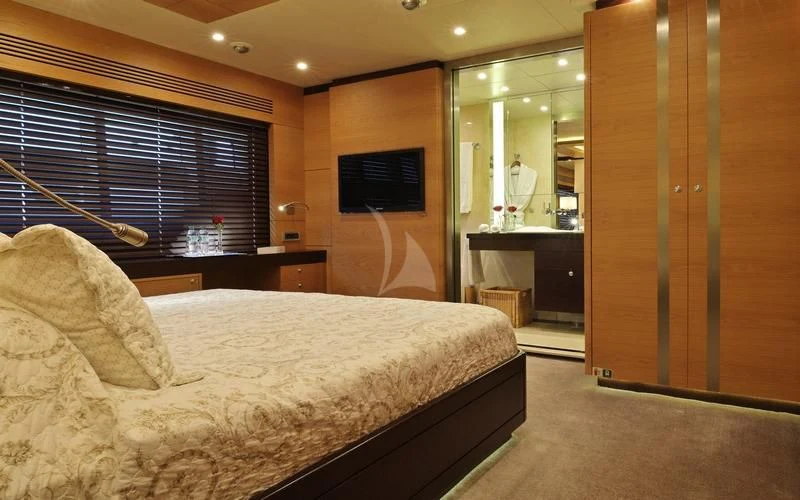 a bedroom with a bed and a tv on the wall aboard TATIANA I Yacht for Sale