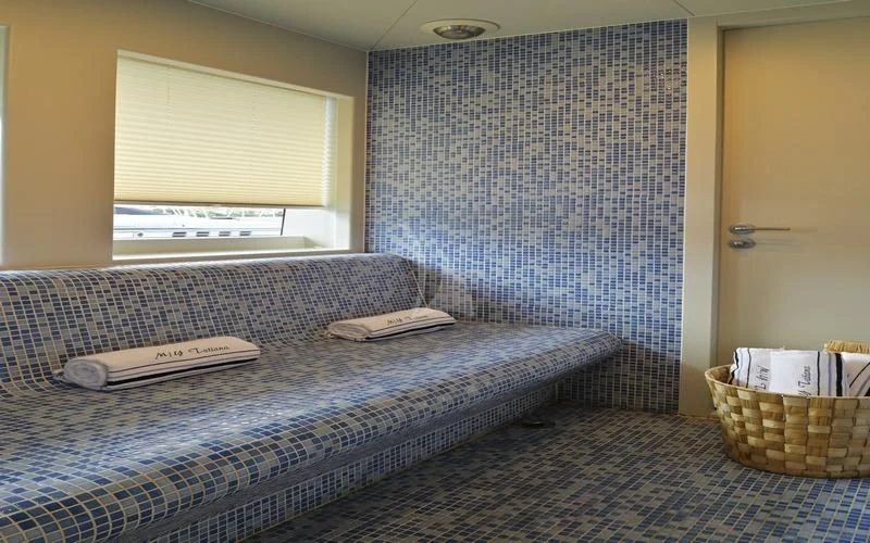 a bed with a blue blanket aboard TATIANA I Yacht for Sale