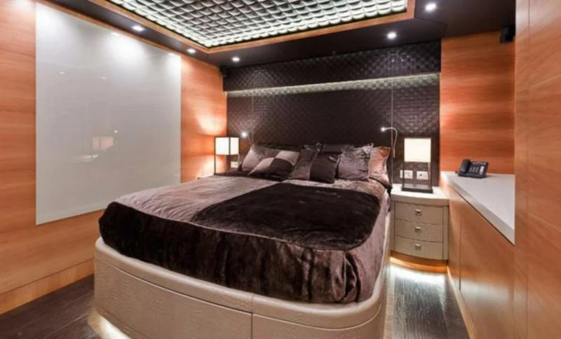 a bed with a black comforter aboard ELIZAVETA Yacht for Sale
