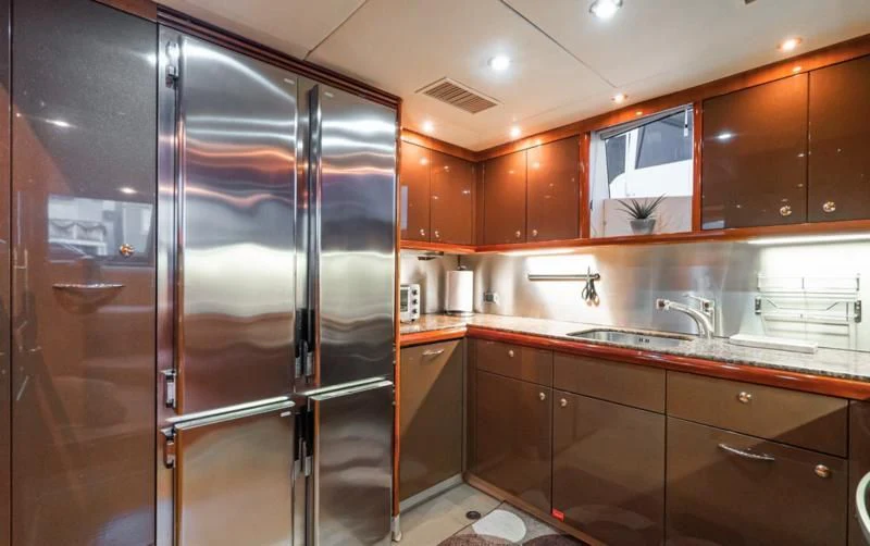 a kitchen with a stainless steel refrigerator aboard NAKOA Yacht for Sale