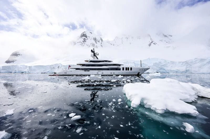 a boat on water with a snowy landscape in the background aboard INFINITE JEST Yacht for Sale