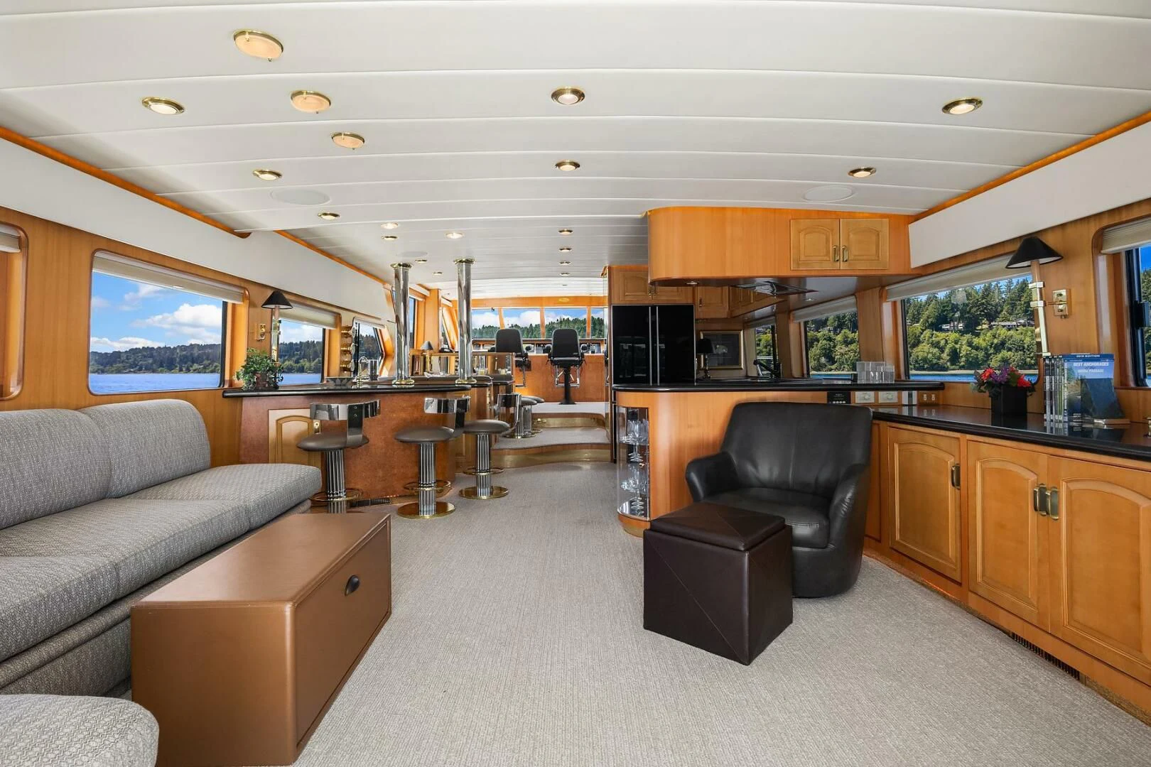 a living room with a leather couch and a large window aboard QUE SA-RAH SA-RAH Yacht for Sale