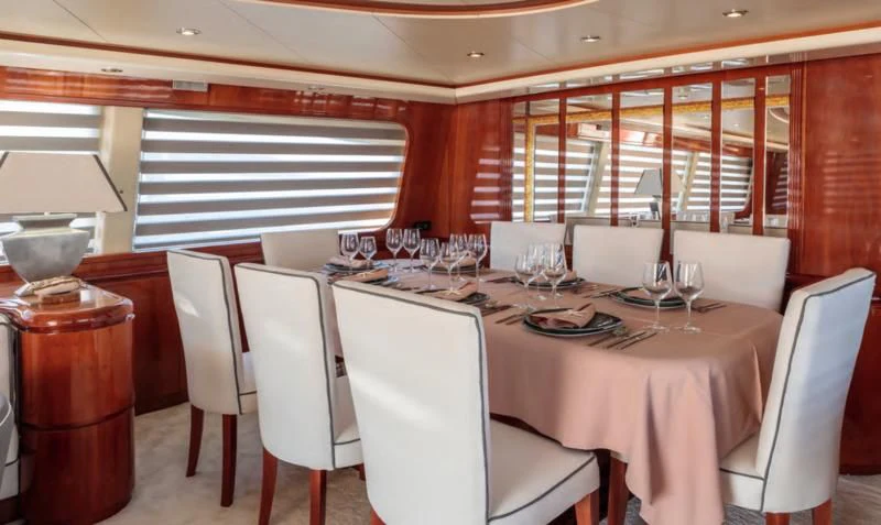 a dining room with white chairs and tables aboard EFMARIA Yacht for Sale