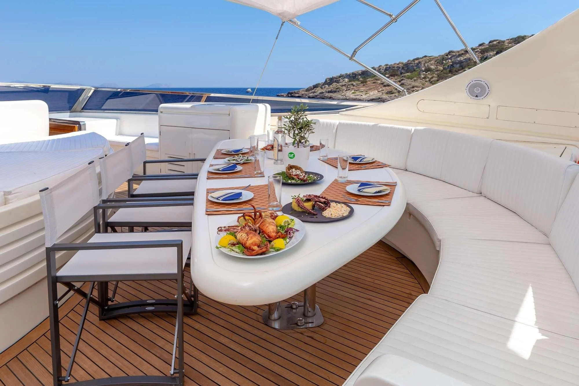 a table with plates of food on it on a balcony aboard EFMARIA Yacht for Sale