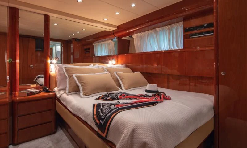 a bed with a white sheet and pillows on it aboard EFMARIA Yacht for Sale