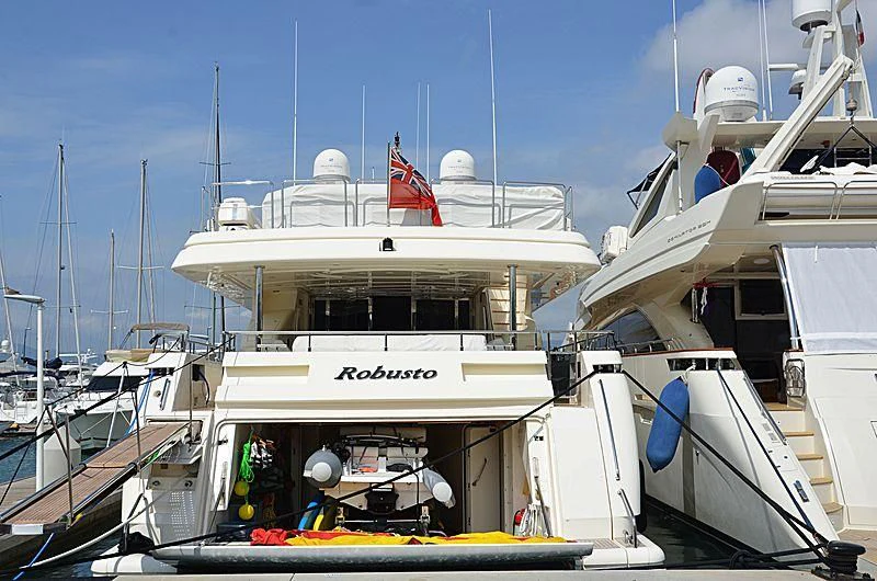 a boat with a flag on the deck aboard ROBUSTO Yacht for Sale