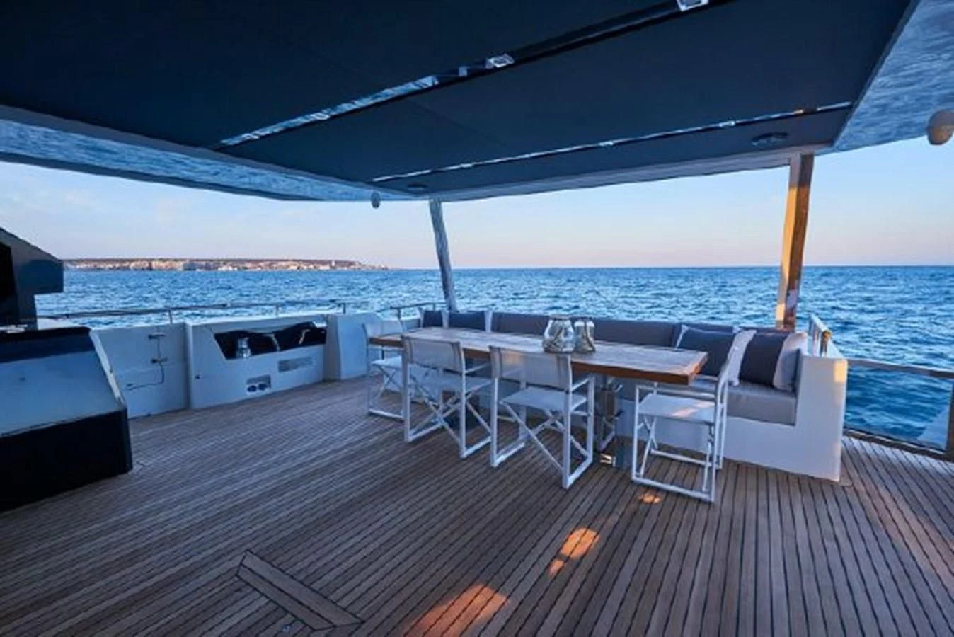 a deck with a table and chairs on it aboard 2021 ASTONDOA 100 CENTURY Yacht for Sale