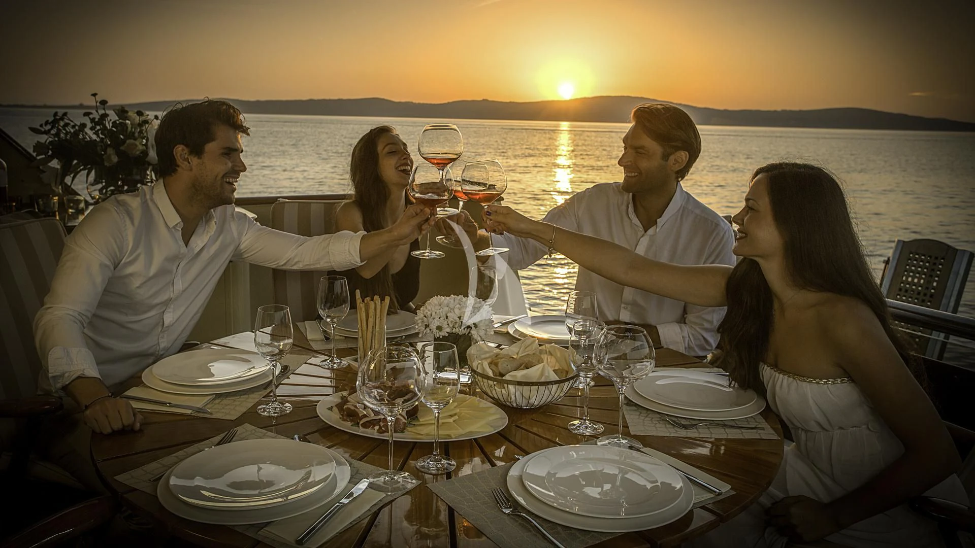 a group of people sitting around a table with wine glasses aboard AURIANE Yacht for Sale