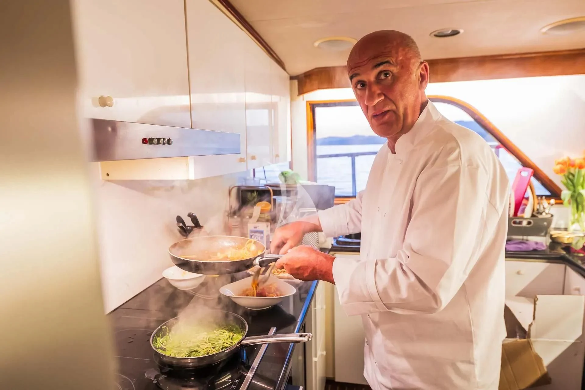 a man in a kitchen preparing food aboard AURIANE Yacht for Sale