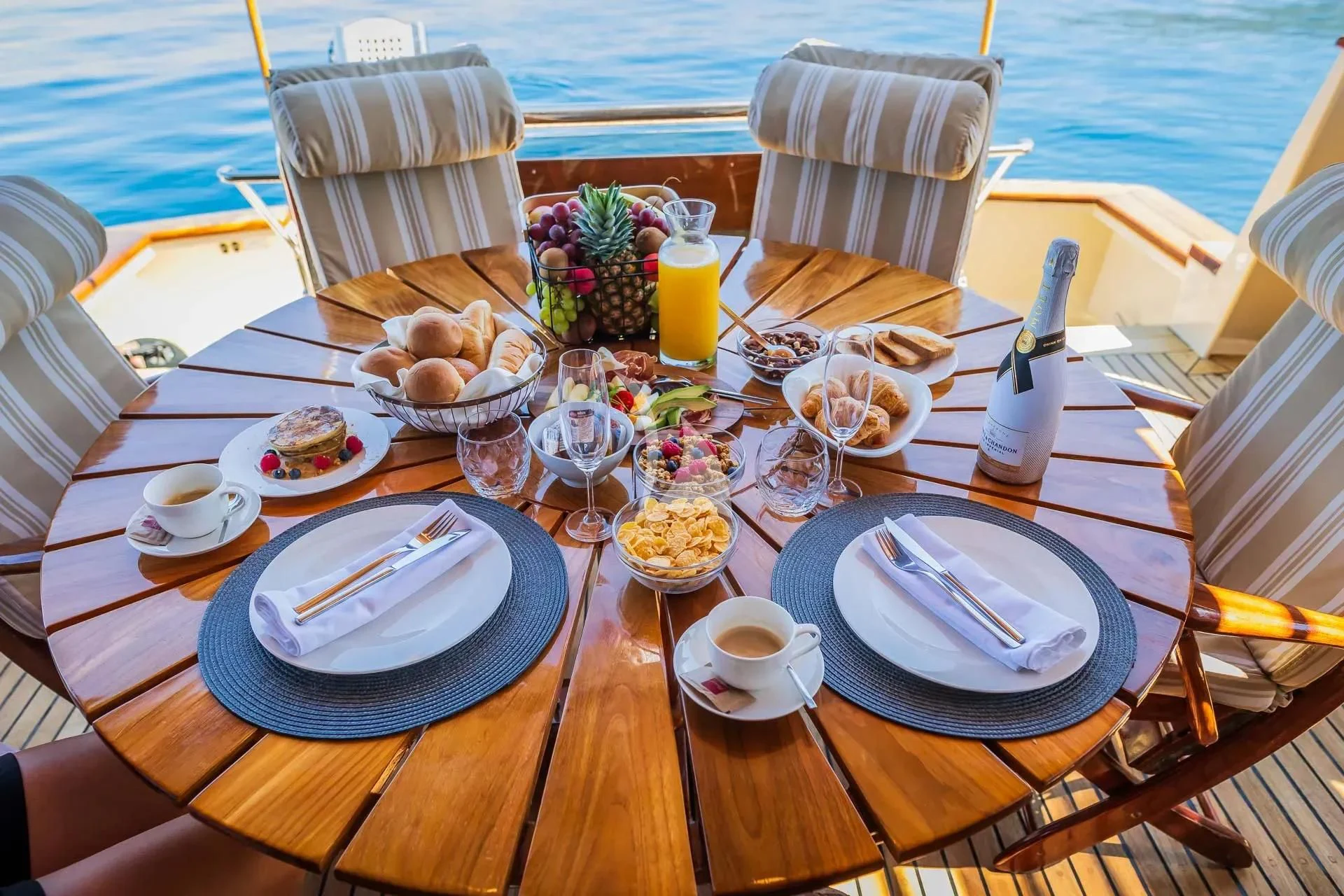 a table with plates and glasses on it aboard AURIANE Yacht for Sale