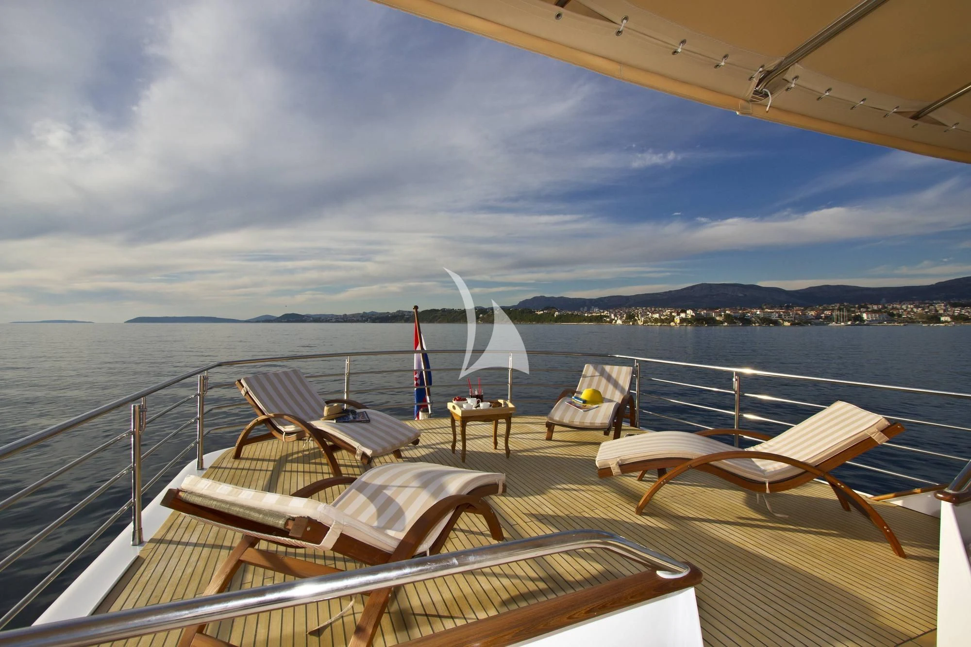 a deck with chairs and tables on it by the water aboard AURIANE Yacht for Sale