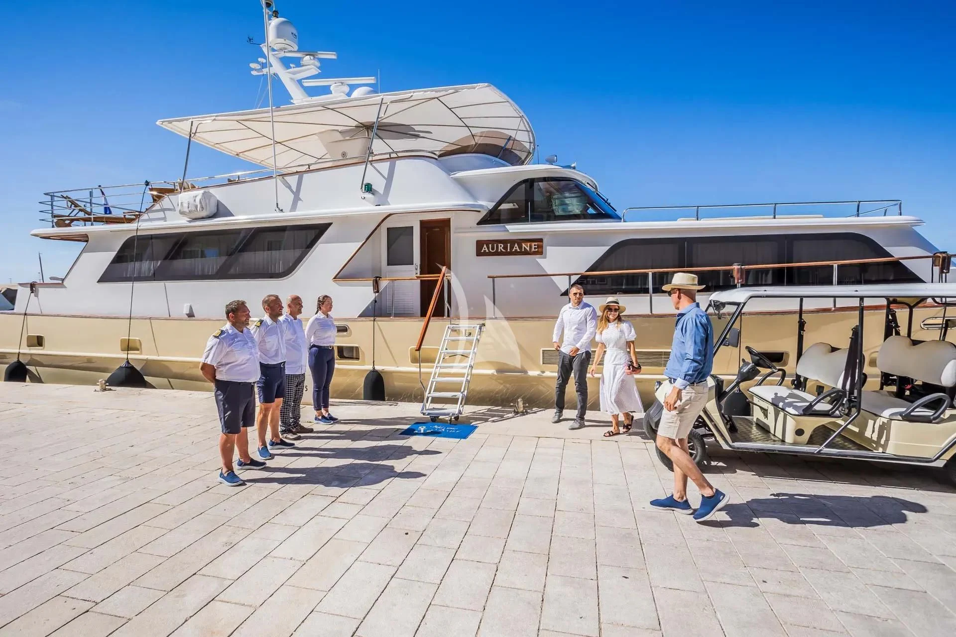 a group of people standing next to a boat aboard AURIANE Yacht for Sale