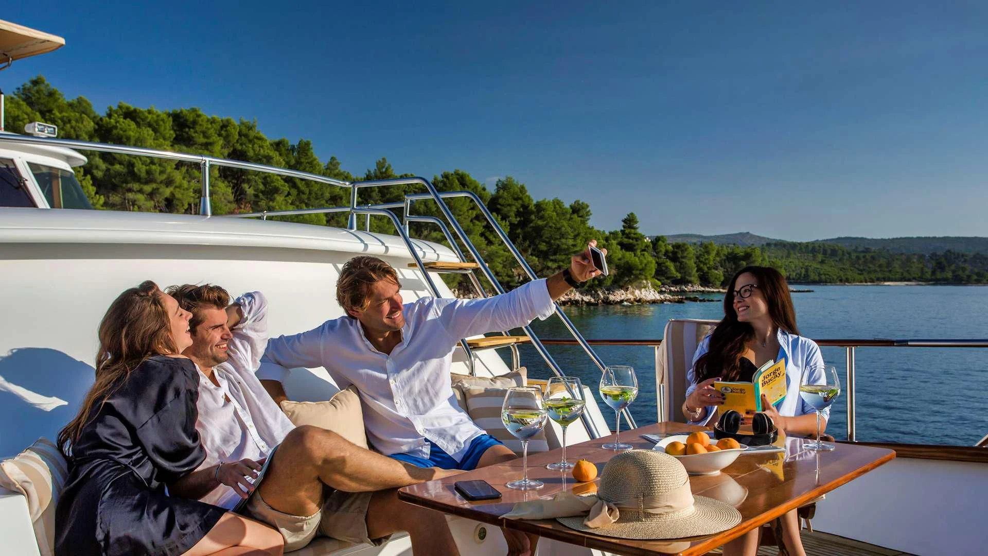 a group of people sitting around a table with food and drinks on it aboard AURIANE Yacht for Sale