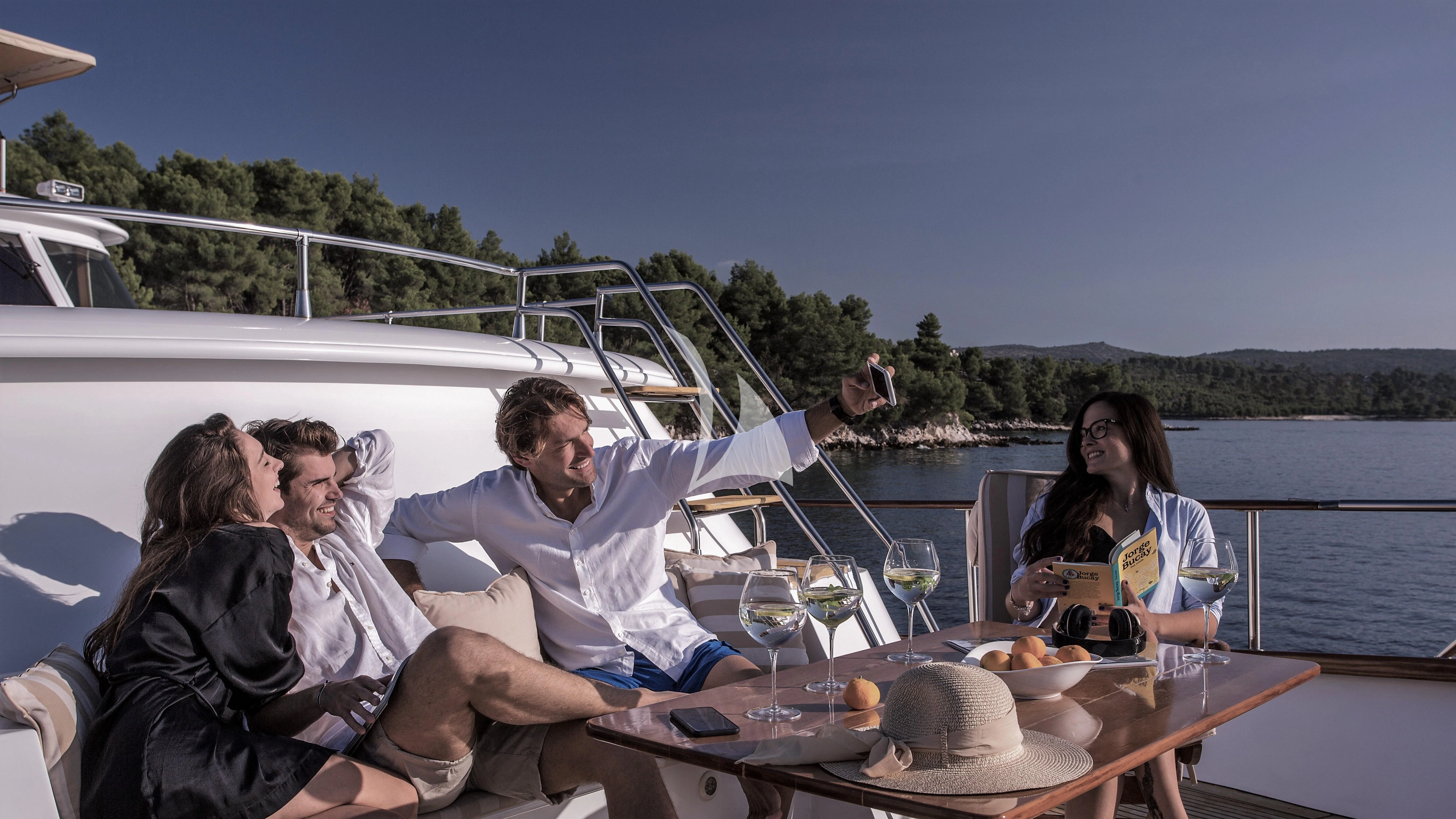 a group of people sitting around a table outside aboard AURIANE Yacht for Sale