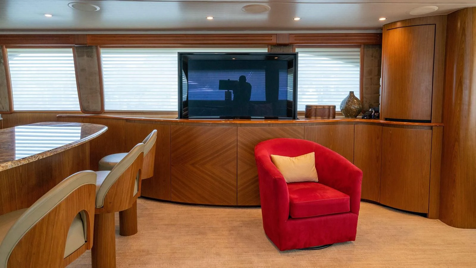 a room with a red chair and a television on the wall aboard DONE DEAL Yacht for Sale