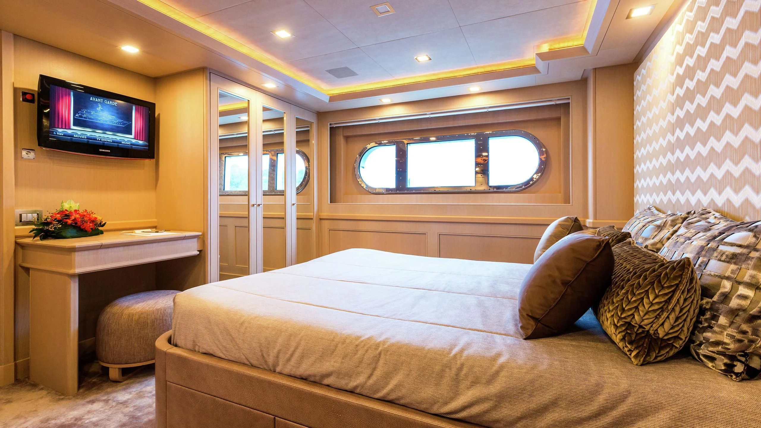a bed with pillows and a television aboard PHOTON Yacht for Sale