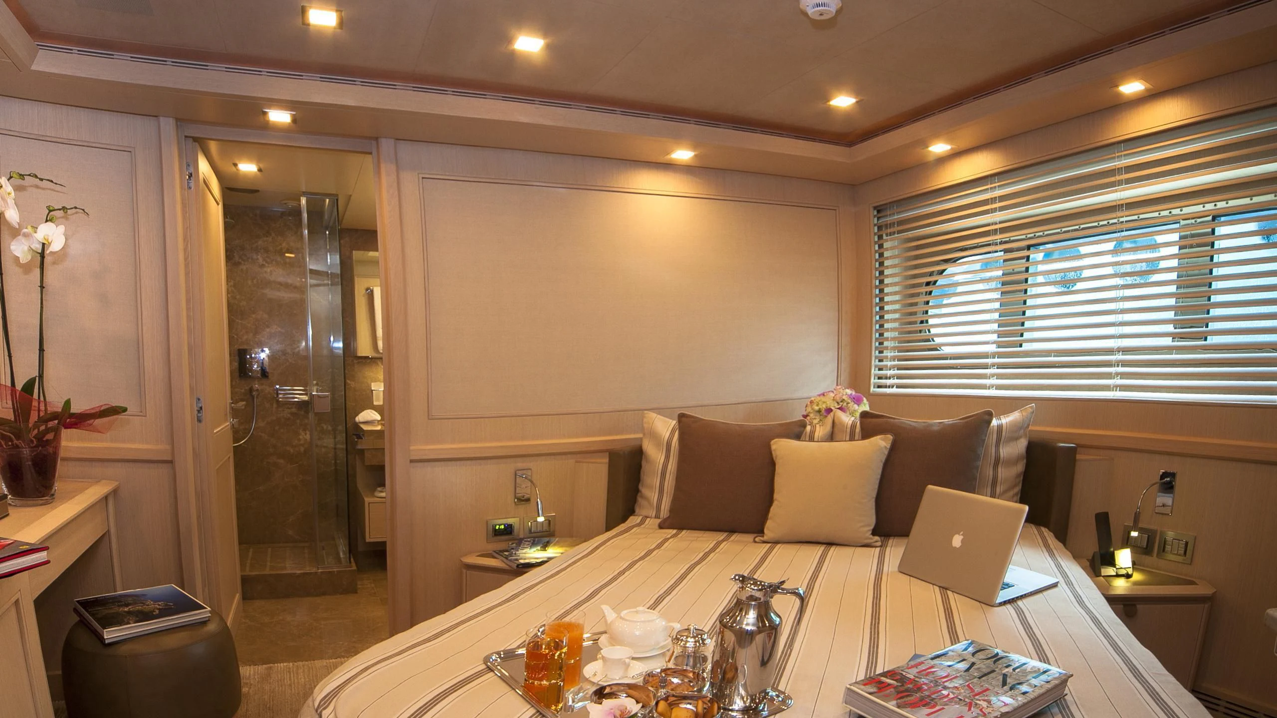 a living room with a white table and a white table with a laptop aboard PHOTON Yacht for Sale