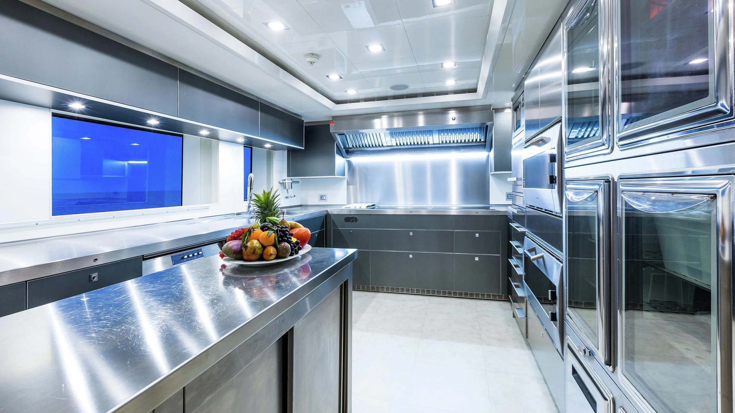 a large kitchen with a bowl of fruit on a plate aboard PHOTON Yacht for Sale