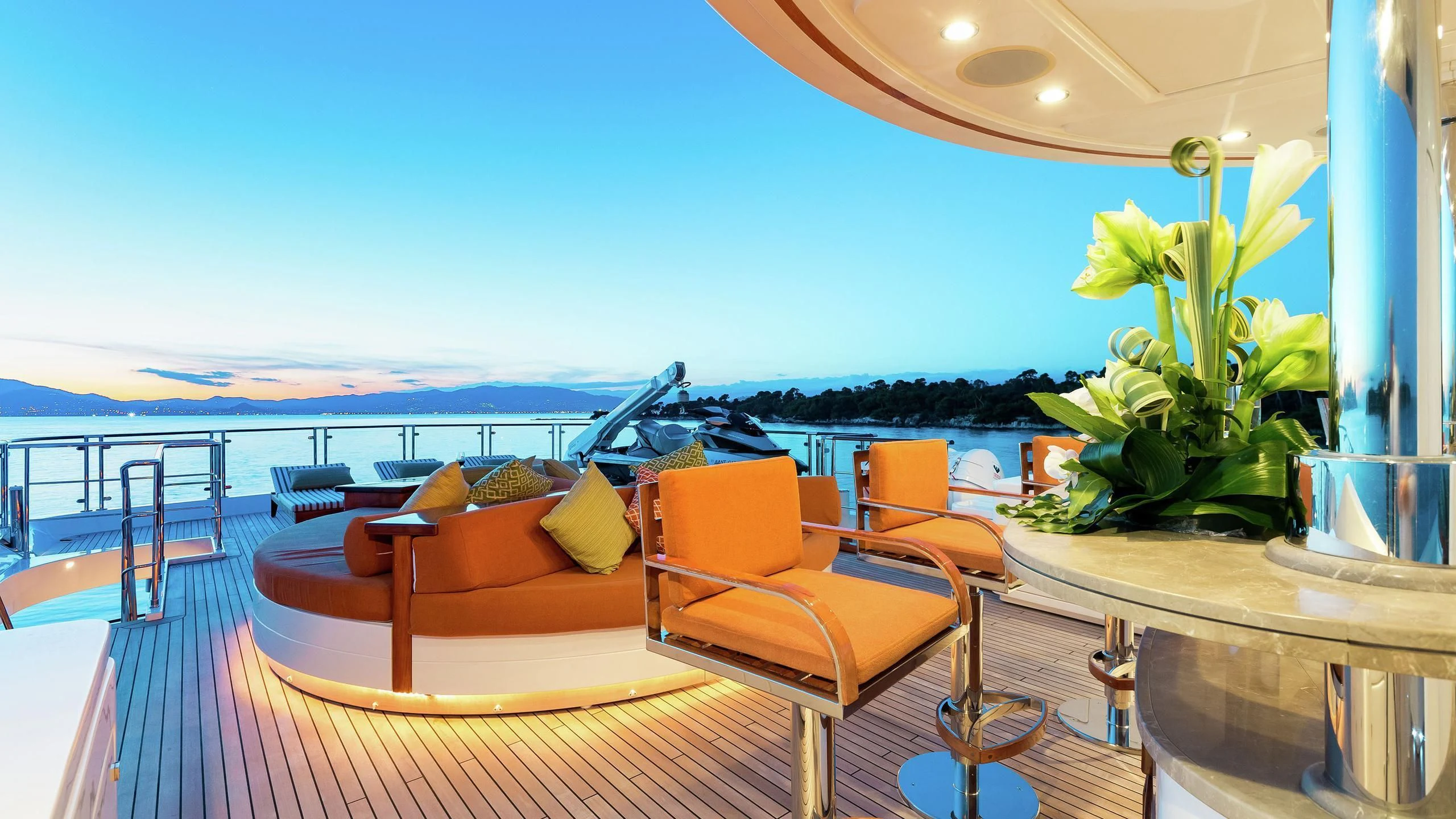 a room with a table chairs and plants on the deck aboard PHOTON Yacht for Sale