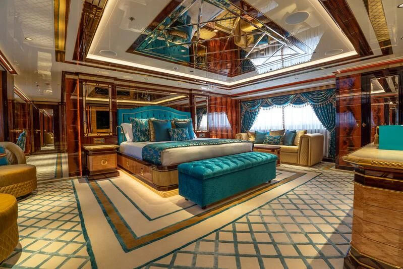 a room with a blue couch aboard JEWELS Yacht for Sale