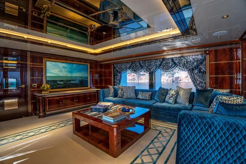 a living room with a large screen aboard JEWELS Yacht for Sale