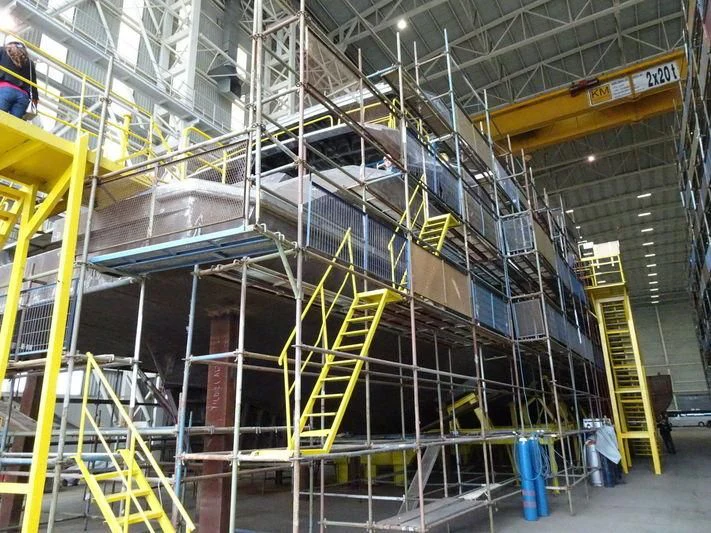 a large factory with yellow and white machinery aboard JEWELS Yacht for Sale