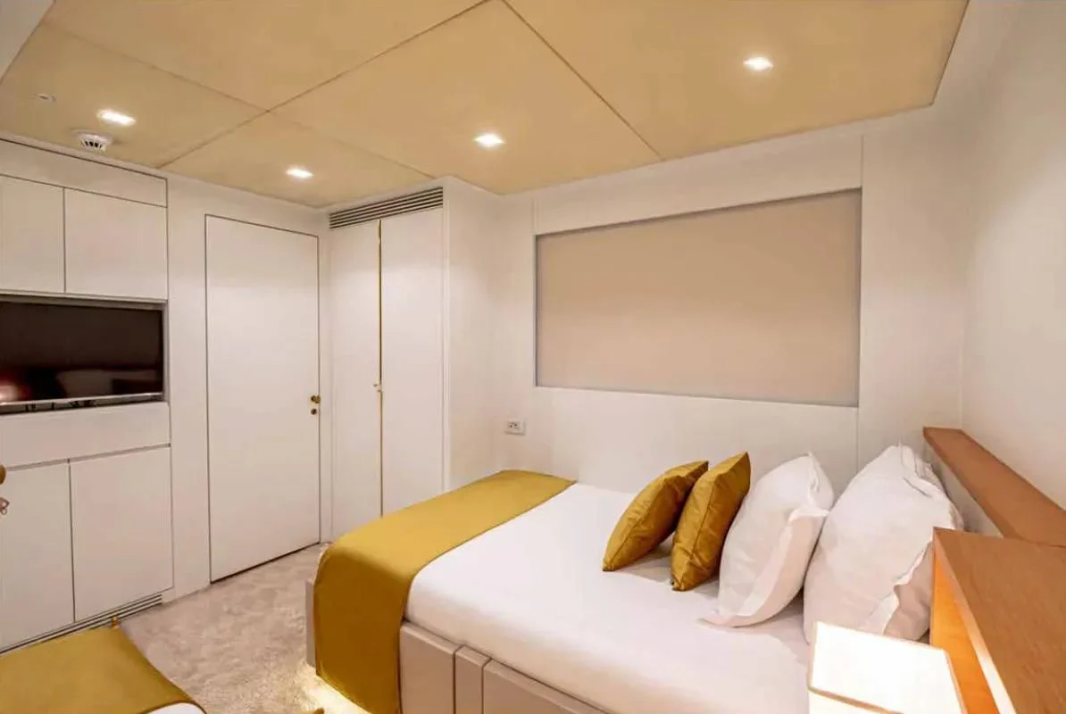 a bedroom with a bed and a tv aboard HARUN Yacht for Charter
