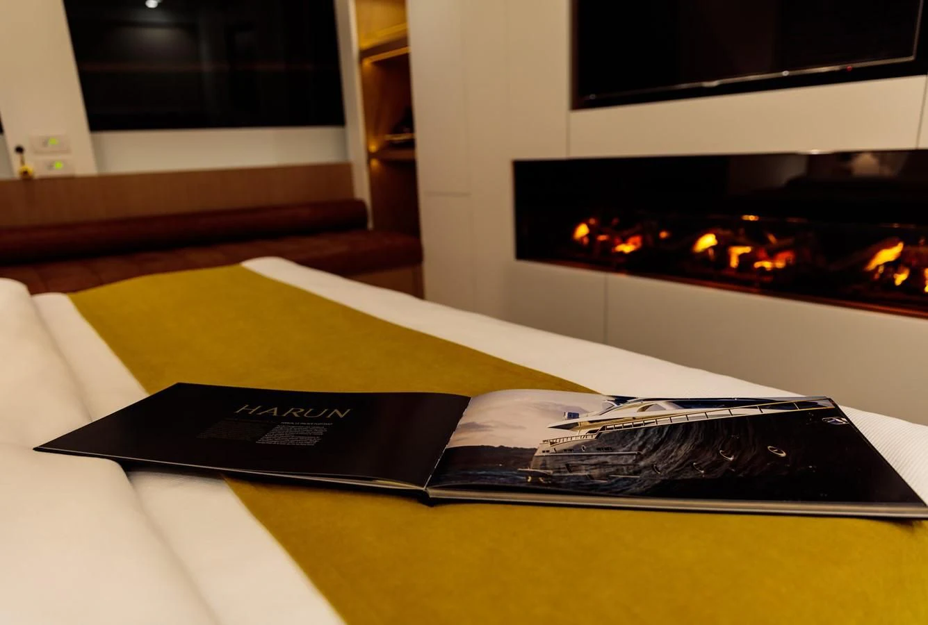 a black rectangular object on a white surface with a fireplace in the background aboard HARUN Yacht for Charter