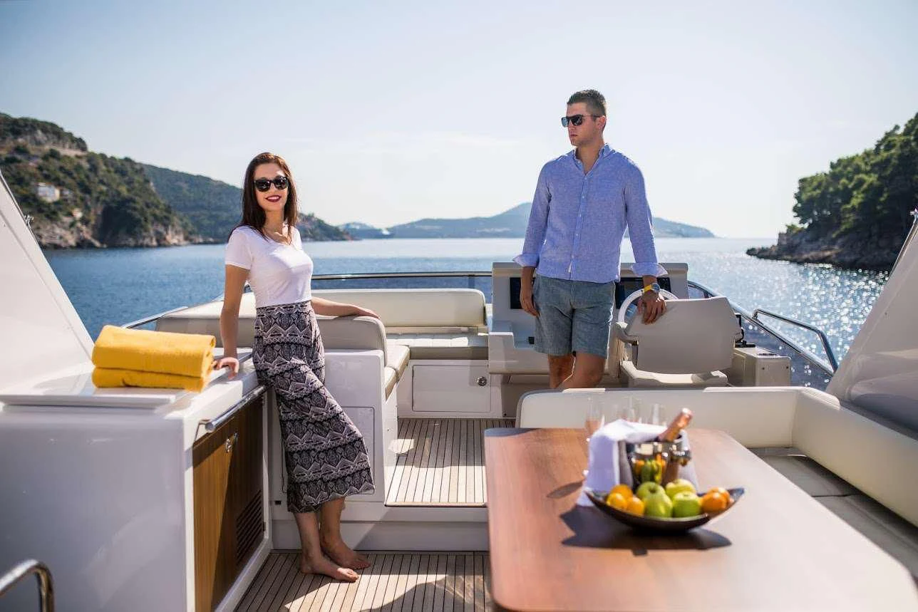 a man and woman standing on a deck overlooking a body of water aboard TAMARA II Yacht for Sale