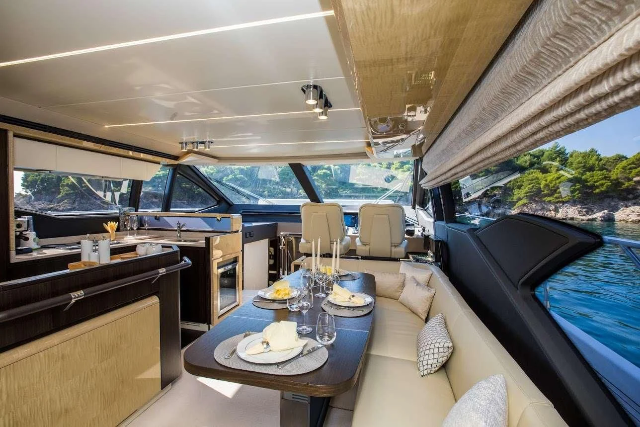 a table with plates and a glass window in a train aboard TAMARA II Yacht for Sale