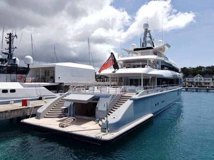 a large white boat docked at a pier aboard MOGAMBO Yacht for Sale