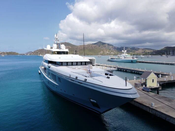 a large white boat sits at a dock aboard MOGAMBO Yacht for Sale