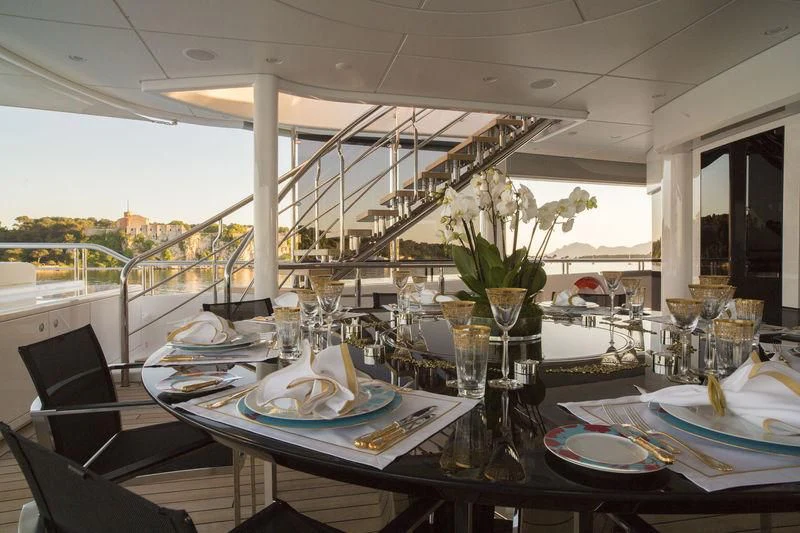 a table with plates and glasses on it aboard MOGAMBO Yacht for Sale