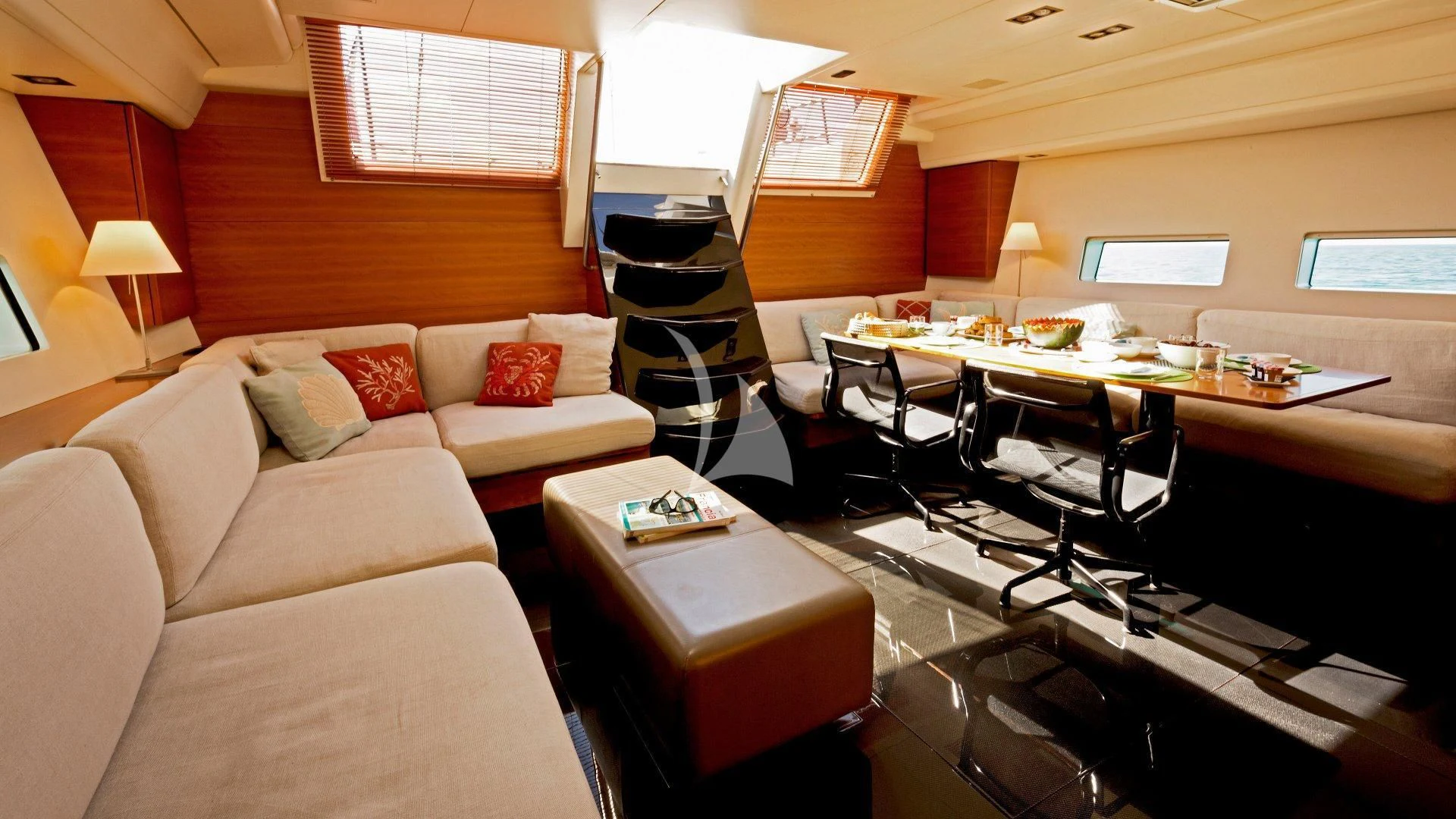 a room with a couch and a table with chairs and a television aboard WALLY LOVE Yacht for Charter