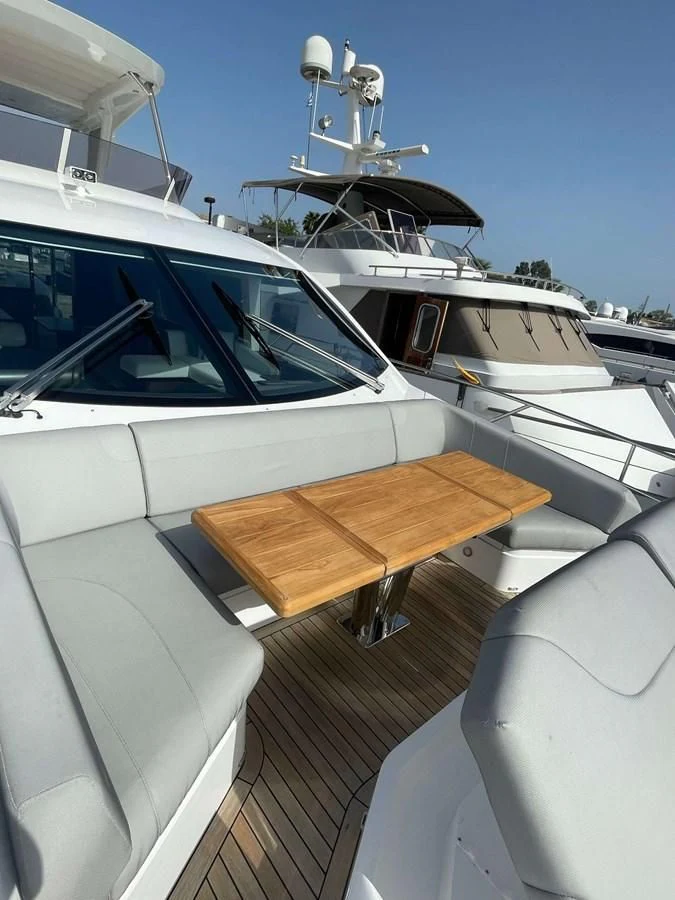 a boat with a wooden table aboard SUNSEEKER 70' MANHATTAN Yacht for Sale
