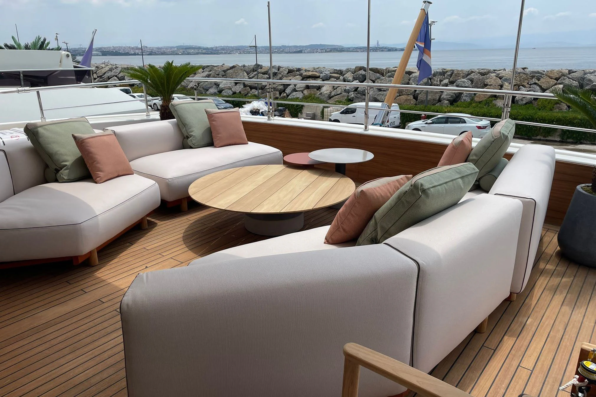 a couch and a table on a deck overlooking a beach aboard AERO Yacht for Charter
