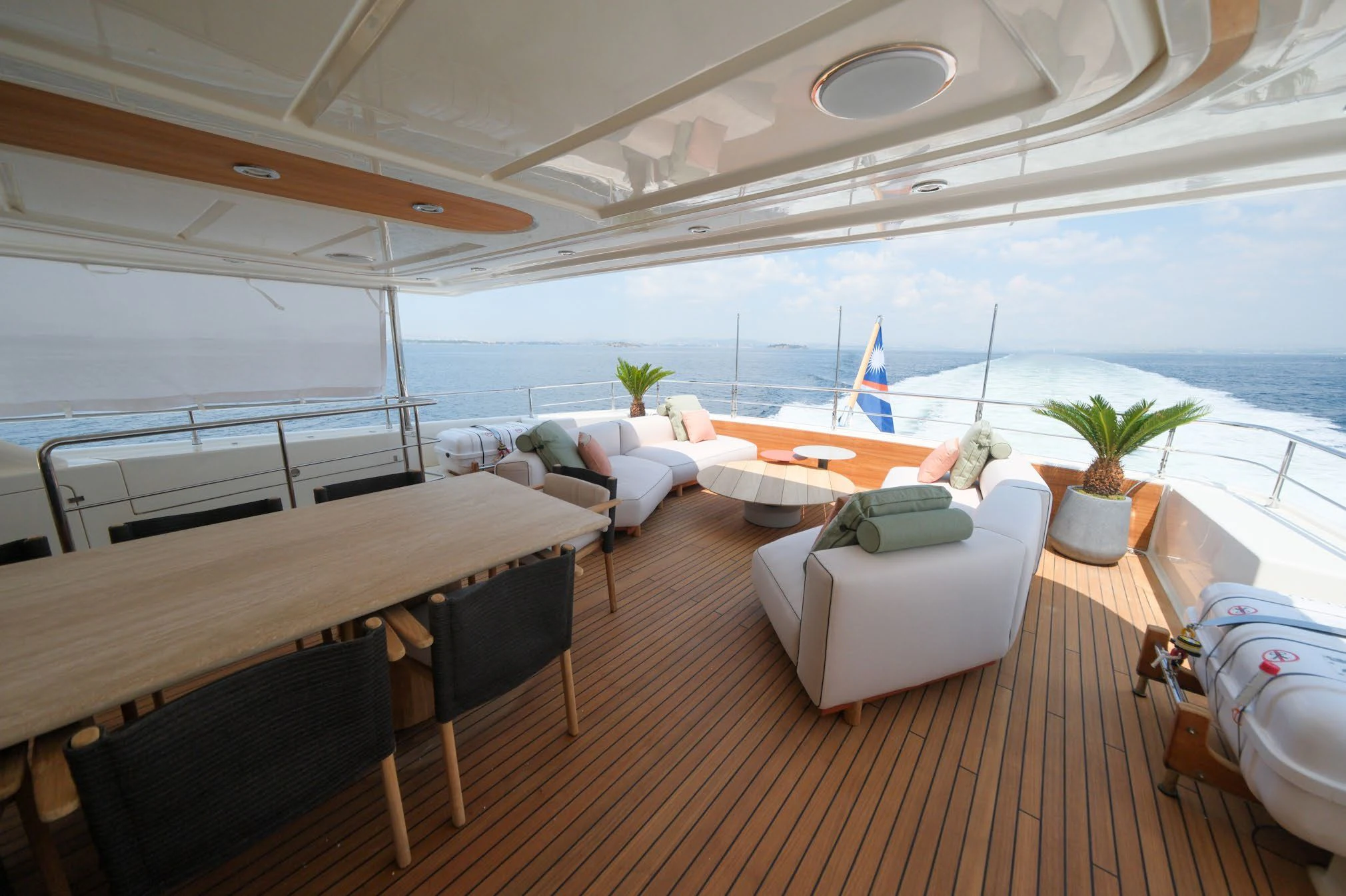 a room with a table chairs and a plant on the table aboard AERO Yacht for Charter