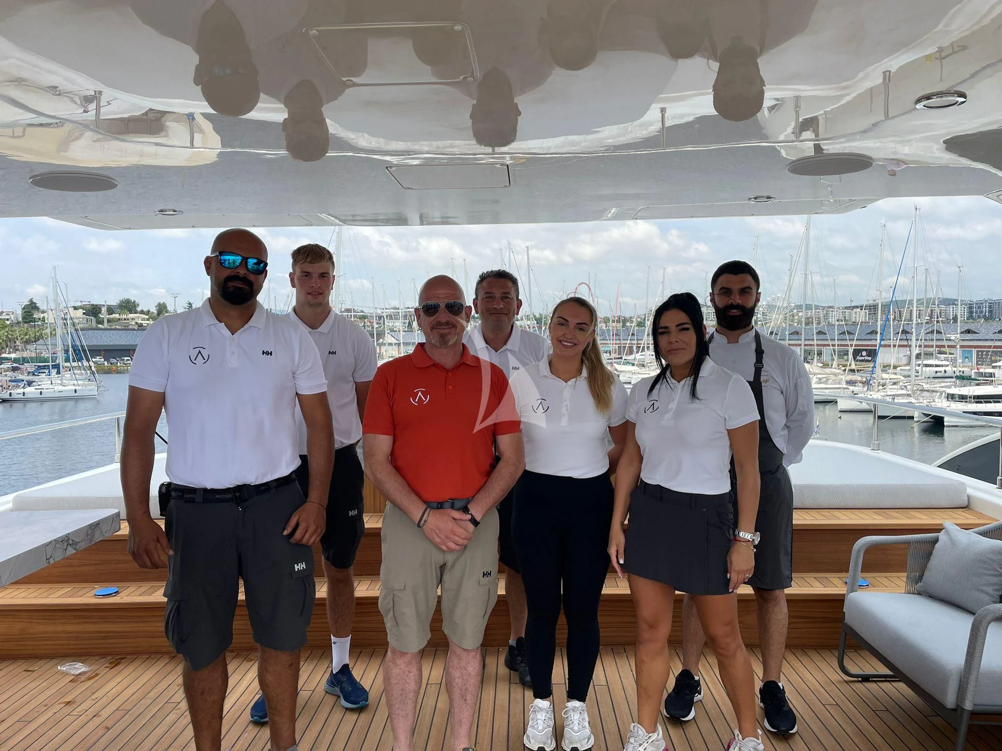 a group of people posing for a photo on a boat aboard AERO Yacht for Charter