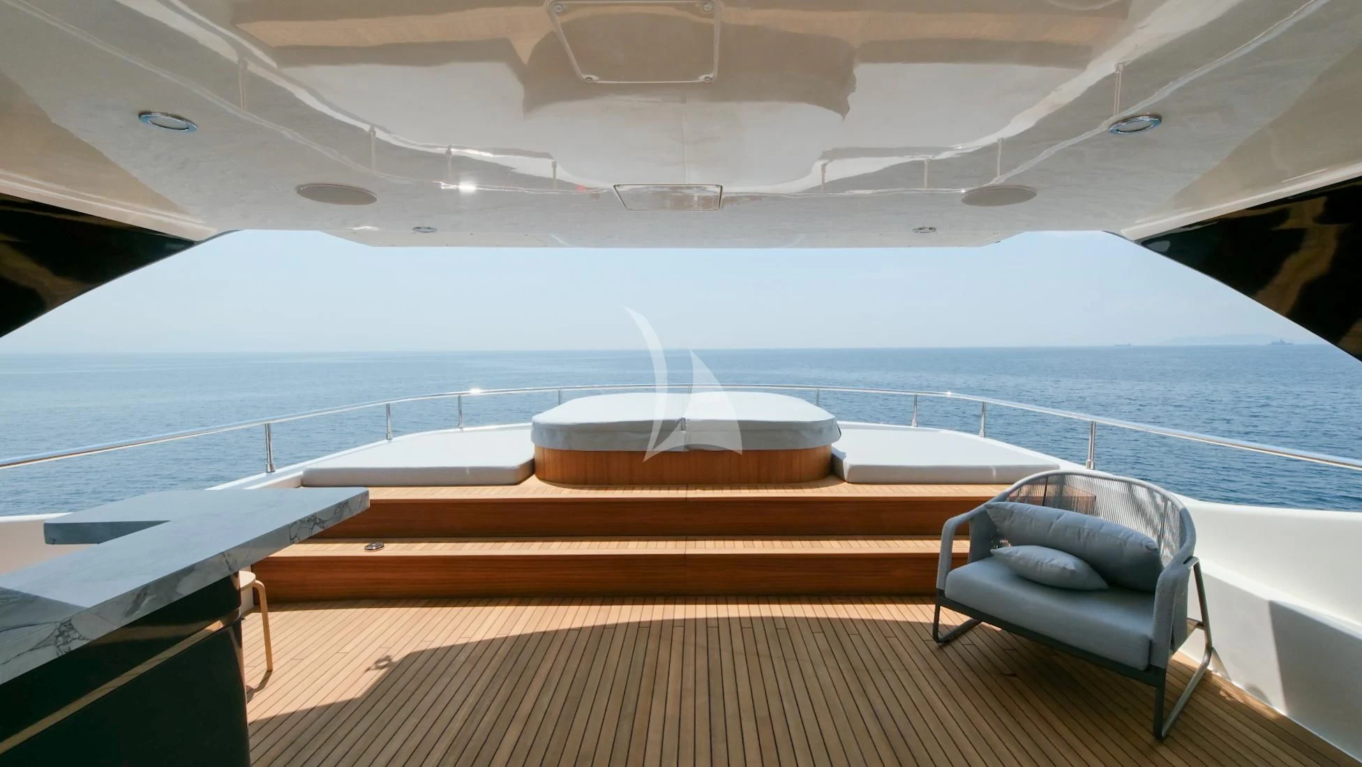 a chair on a deck overlooking a large body of water aboard AERO Yacht for Charter